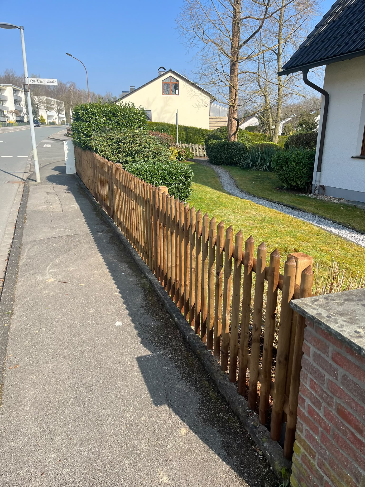 Holzzaun entlang eines gepflegten Grundstücks