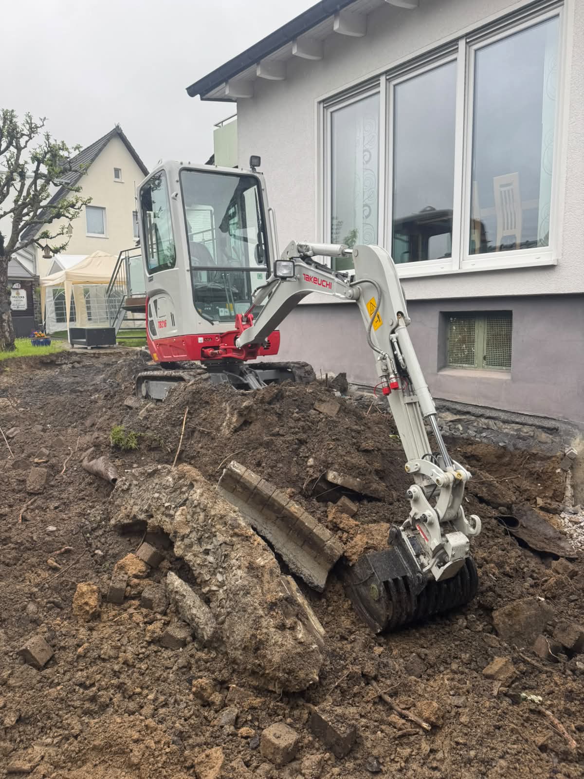 Minibagger beim Rückbau einer alten Pflasterfläche